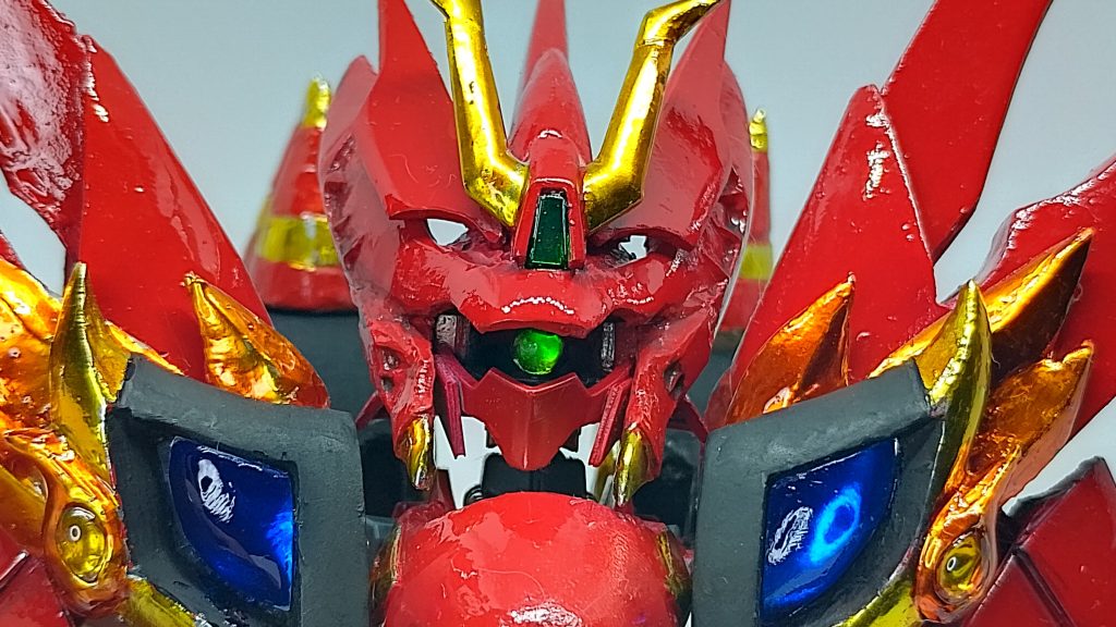 モノアイも含めクリアパーツは全てUVレジンを使用して製作しています。両肩の青い宝石は、鎧にダイソーの樹脂粘土で成形し、製作最終段階で外してUVレジンで転写し、クロムテープの下に貼り付けて切り抜きました。 カラーはGAIA No.44 クリアブルーです。