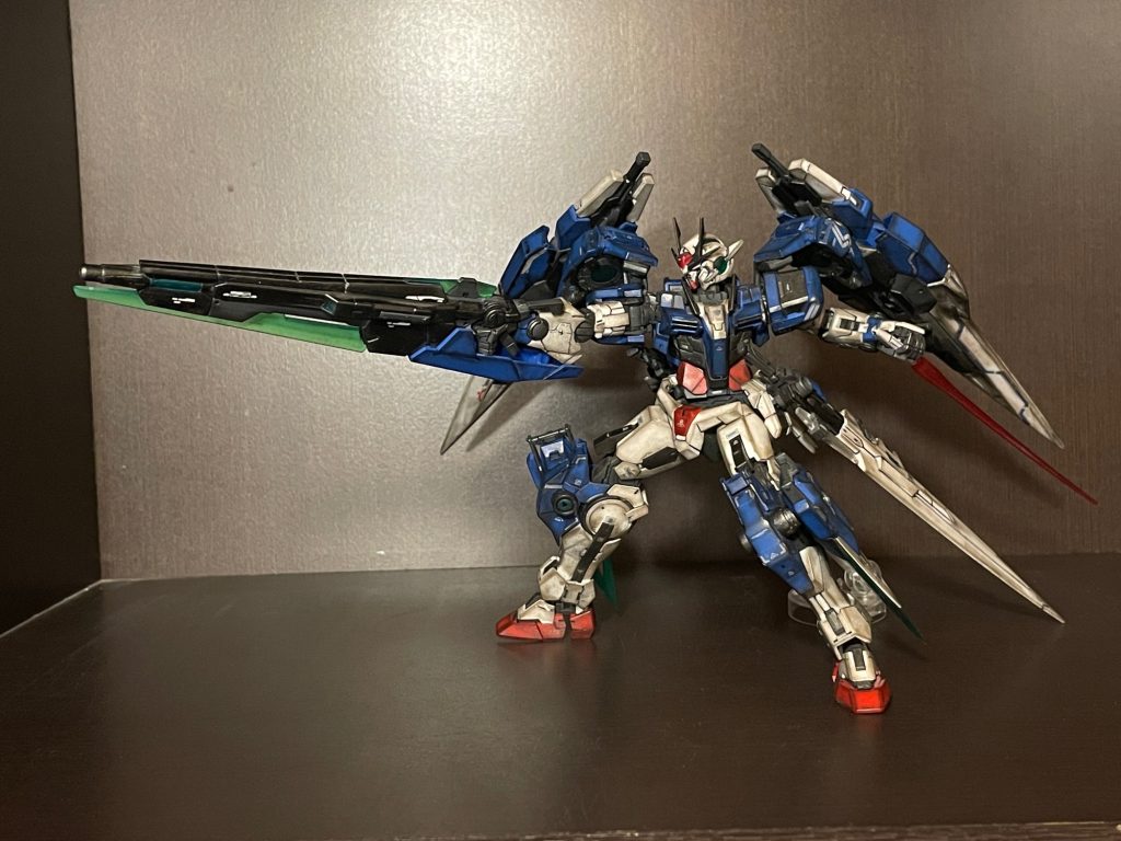 右肩のGNバスターソードⅡがHGセブンソードのものです。バスターソードの円形可動部に小さな針金を接着し、GNドライブの溝に挟み込むかたちで接続しています。かなりポロリしますが、ハマればそこそこ保持します。部分塗装、墨入れ、艶消し、トップコート、汚し仕上。ブラスターも相まって構えた時の横幅迫力が気に入ってます。この形態ならツインドライブの同調はできるのだろうか…