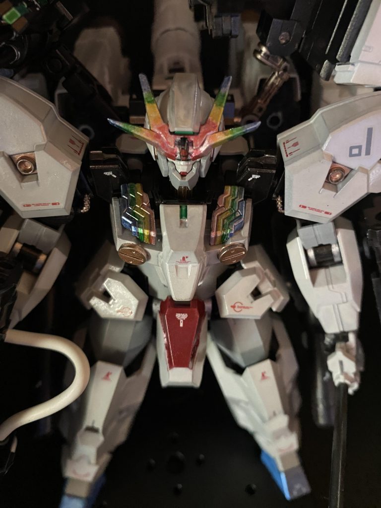 キャリバーンみたく虹色パーメット🌈にしたい!と、アンテナとシェルユニットはレインボーキャンディ塗装。当初、エアブラシ を考えてみたけど、この僅かなパーツのためだけにエアブラシ はしんどいと、横着して筆塗りに変更。下地シルバー→青、緑、黄、赤の各種クリアーを塗りちょっとサンバカラーみたく色彩がハッキリし過ぎになりましたが、仕上げにパールホワイトを筆塗りで、いい感じに淡くなりました。本体ほぼ唯一の改造点、胸部ラジエーターはコトブキヤ丸モールドを接着。1箇所だけ赤を入れて締めたいと思い、胸部ハッチか、ガンダムで言うV字マーク部か迷いましたが、後者にしました。