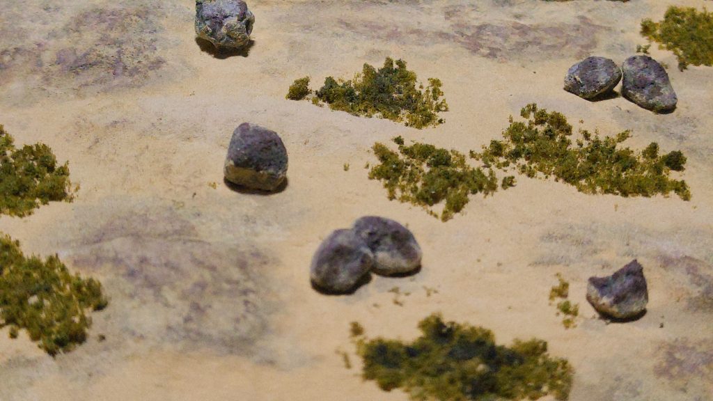 テクスチャペイントの上からクレオスのウェザリングカラー(シェードブラウン)を重ねました。境界線と濃くなり過ぎた部分は、テクスチャペイントをドライブラシして馴染ませています。あとは軽石をウェザリングカラーで着色して配置、色付けしたスポンジを削って草に。