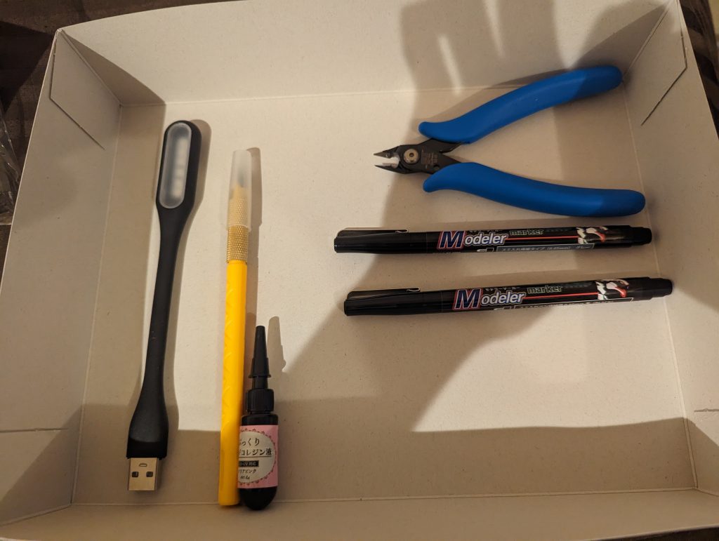 現地調達の工具達、ニッパーはプラモ屋で買ったゴッドハンド製のちょっといいヤツですがその他は全部100均で調達しました、出先でこれだけのものが簡単に揃えられるのはシンプルに凄い時代です。ちなみにヤスリは買ったつもりが買い忘れてました、このせいで処理が適当に…。