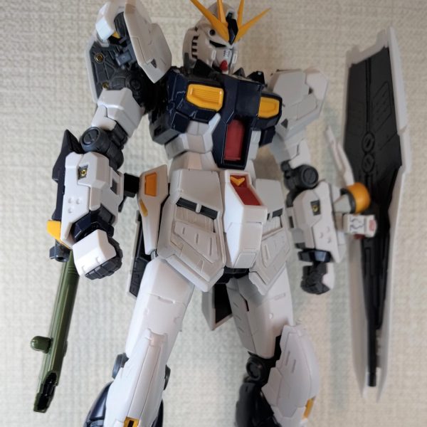 RG・νガンダムちまちま改造録。細かいディテールアップとか進めてました。そろそろ塗装に入ろうというところです。メイン写真：目尻の上、ひさしの部分をちょっと剃りこみました。心なしかキリっとした目付きになったと思います。左手の盾は従来通りに肘の外側へ構えられるほか、ジョイントを前方へ伸ばせば前腕部の横に付けることも可能です。右腰にさげているのはデスティニーの長射程ビーム砲・・・当初の計画ではこれをバックパックの右に装備して、左右の重量バランスがFファンネルで偏るのを緩和しようとしてたんです。結局ダブルFファンネルになったので不要となりましたが、「絶対持たせる！これはもうνの武器なんだ！」と意地になってしまい、右腰にジョイントを設けました。位置が下がったおかげで、意外と背中にファンネル乗せても喧嘩せずに動くんですよ写真１：バックショットです。脚のパイプをメッシュワイヤーに替えています。今回はガンダムマーカーのメッキシルバーです写真２：軽くポージングを。膝関節のシリンダーを真鍮パイプに替えました。長さ調整がめっちゃ面倒でした！（1枚目）