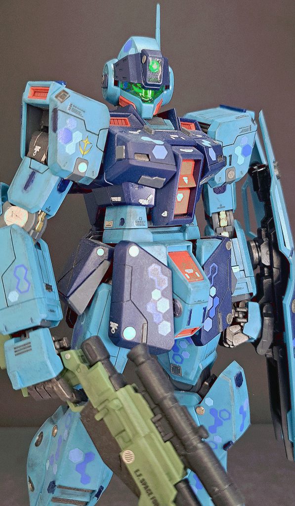 今回のポイントとして、カメラアイの輝きを強くすることを意識しました。光が反射する箇所を増やすことが重要とどこかで見たので、クリアパーツの上に100均の装飾テープを貼り、その上からレジンを塗って固めてあります。一応内部フレームもシルバーで塗装してあります。自分としては、けっこう上手くいったのではないかと思っています。光の反射が複雑になって、なかなか面白い感じになったという感想です。肉眼で見ると青く見える部分もあるんですよ。