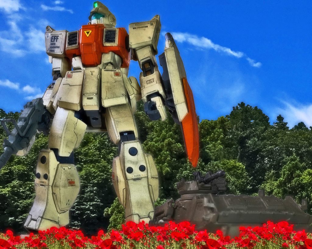 「マリアさ〜ん」2人は声のする方を向くとホバートラックからニッカードが歩いてくる。「大尉さん」マリアはニッカードを見ると優しく微笑んだ。「物資の積み替えが終わりましてな。今日はいつもより少し気持ちをつけました」「いつも助かりますわ。こちらからも大尉のお好きな缶詰とウィスキーが手に入ったのでお渡しします」「いやはやすみませんな」マリアと話すニッカードの顔は緩んでおり軍人というよりただの人の良い老人であった。「こちらのジャーナリストさんは大尉さんのお連れで?」「そうです。従軍記者と言うやつでして。どうじゃ、収穫はあったかの?」「ええ、ここの花畑について」「まあ、あまり聞きすぎるのも迷惑がかかるじゃろうて、後はワシが引き受けよう」「では大尉さん、また」マリアは軽く会釈をした。ニッカードも帽子を脱ぎ頭を下げるとネスカを引き連れホバートラックに帰っていった。