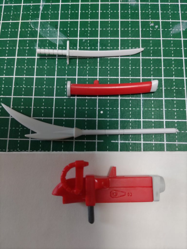 刀は刃先をあまり尖らせすぎるのもイメージと違うので、パーティングラインを消したのみ。鞘は鐺の形が変だったので、ヒートペンでランナーを盛り付け、鞘の反りに合わせて削りました。　　　　納刀すると刀がガッチリハマって塗装が剥がれるので、鯉口を削って緩くしています。　　　　　　　　　　　　　　　　　　　　　加工した脚部に干渉するため、接続軸を少しカットしています。薙刀はバックパックとの接続軸をカット。ライフルはスプリングギミックをオミットしたので、トリガーを接着、固定しています。　　　　　グリップは塗装剥げ防止のため、グレーのKPSランナーに変更して未塗装で仕上げました。