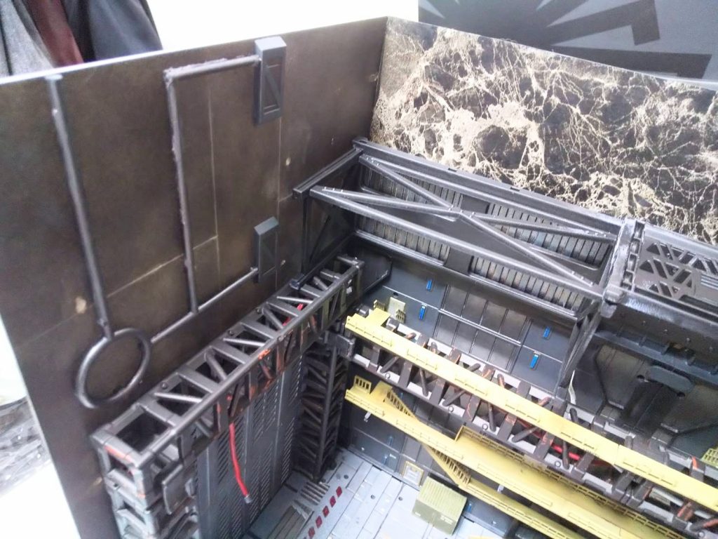 背景壁、正面の広い大理石柄の方はプラ板に100均のカッティングシートを貼ったもの。左の狭い方はプラ板にテキトーにパネルライン引いて、黒サフした上にウェザリングマスターの色んな色を塗りたくり、端切れランナーとジャンクパーツでちょっとディティール足したもの。もうちょっと凝ったモノを作るつもりだったけど、端切れランナーの厚みですらトラスと干渉してクリアランスが無かったので手抜きでコレで終了w