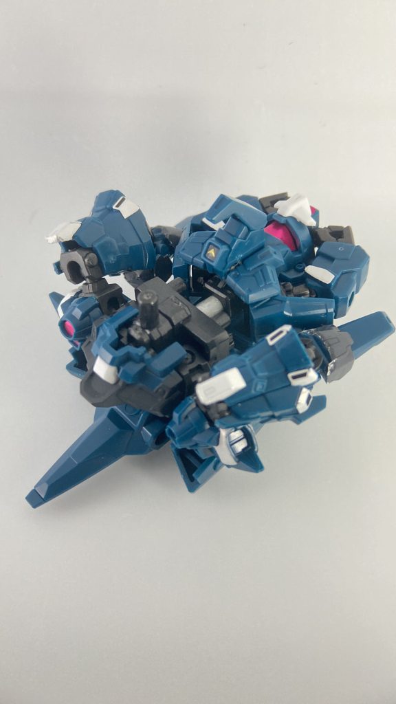 変形④(裏返した写真)腰を外して背中に増設した3mm軸に取り付けます。頭部が余るので両手で抱えておきます。