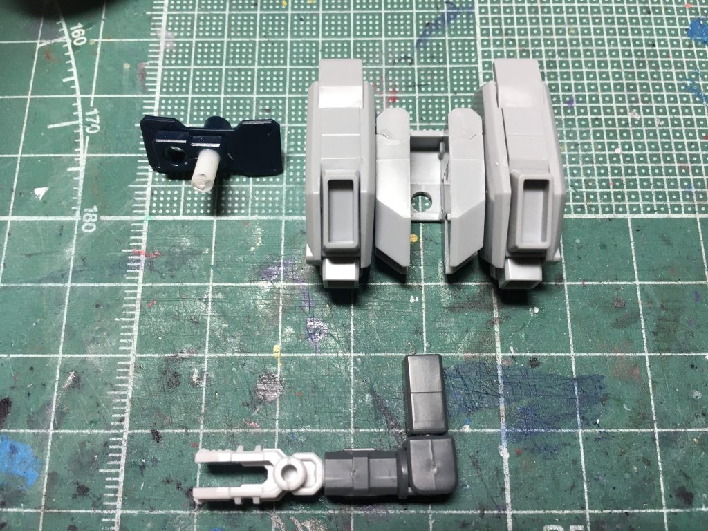 バックパックは元のスタビライザーを撤去して3mmプラ棒でゲルググの背面パーツに貫通させ、武器マウント用のサブアームの接続部を設けました。側面の角ピンを切り取り、丸穴は塞ぎました。周囲の隙間はウェーブの軽量エポキシパテで埋めて成形。