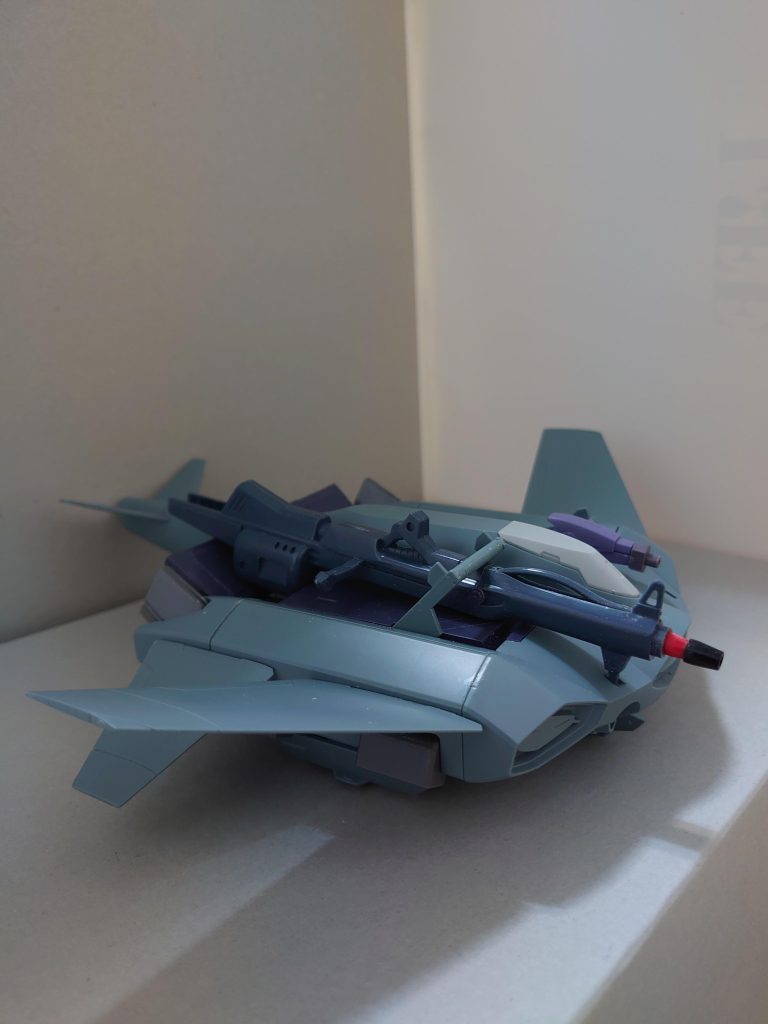 ティックバラン(バスターランチャー装備)【概要】pastel*palettesのドラムス・大和麻弥がMA(モビルアーマー)枠で制作したガンプラ。元のティックバランが機体正面下部に装備しているビームカノン2門とは別に、機体面舵側に180mm小型榴弾式バスターランチャー、取舵側に65mm速射砲を装備する。SFSとしての機能も有しており、MS1機を載せられるが、推力の一部を火力に振り向けたため、この状態でさらに機体下面にMSを牽引するということは不可能になった。