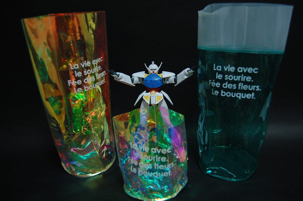 seriaのオーロラアレンジミニポットの中に自転車のライトを入れて、それをカメラの手前などに持ってきて撮影しました。どれだけボケさせるかで素材感や質感が変わり、ポットをグチャグチャひしゃげると色味や光り方が変わって色んなアレンジや調整が可能です。ターンエーは撮影用に墨入れと額の模様だけ塗装したものです。