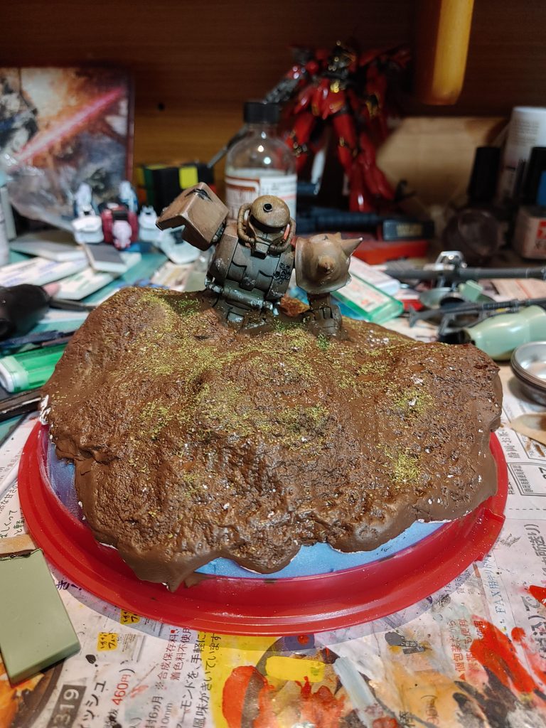 こんな感じの地面にしました。素材は紙粘土です。戦いで木や雑草等が消えてしまった感じにしたのですが....この緑はいらなかったなか？