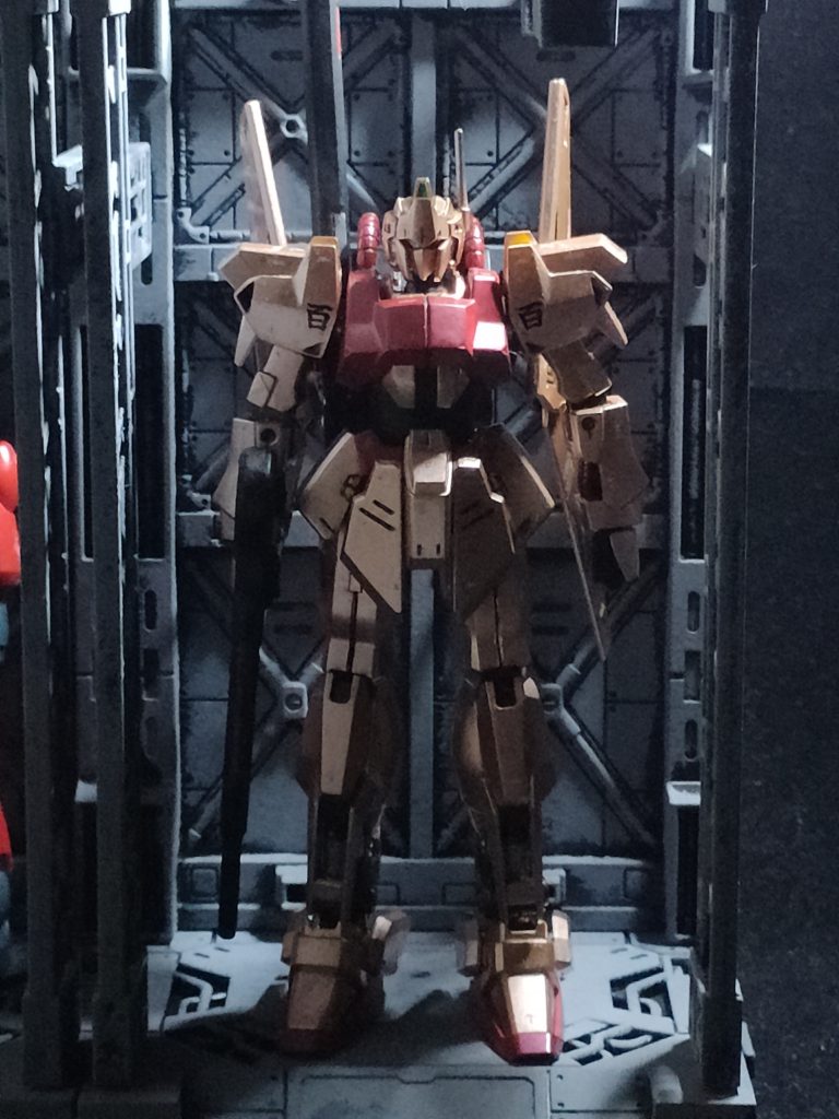 あくまでクワトロ大尉搭乗機なので百式の金色の特徴を残してゴールドピンク（シルバー２：ゴールド1：メタリックレッド1）に調色したもので筆塗り塗装しています。写真では普通に金色に見えますが、昼間に見るときれいなシャンパンピンク色に見えますがなぜか夜見ると銅色で、結構色の変化の見甲斐があります。胸部はシャアスタイルらしく赤系ですがメタリックレッドをつや消ししています。背景は１００均のアレをスポンジ塗装しました。噂通りいい感じです。