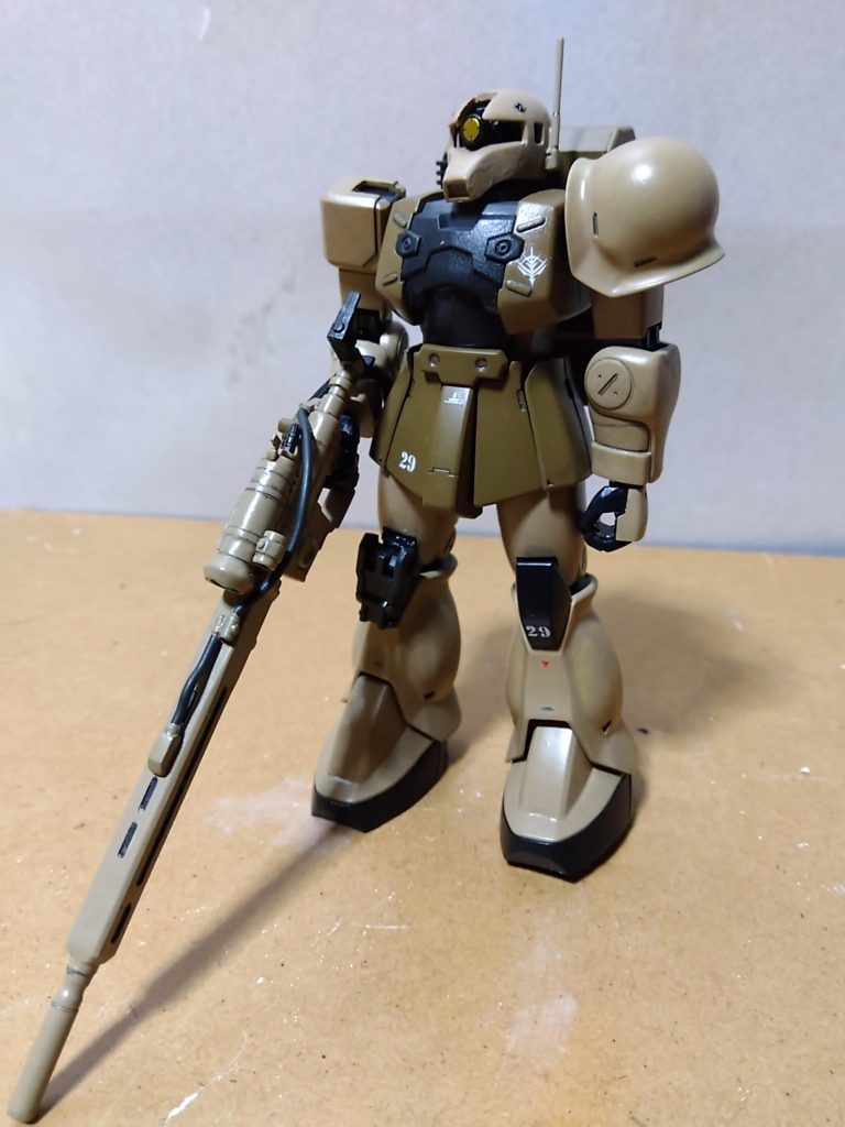 正面素立ちです。 使用したキットはHGUCザクⅠスナイパータイプです。 基本塗装はライトブラウンにニュートラルグレーを混ぜた砂色と、ミドルストーンとオリーブドラブにレッドブラウンを少量混ぜた自作「ダークアース」です。 以前投稿した「旧型ザク(リアルタイプカラー)」や「ルッグン」に使用した色にミドルストーンを足してやや明るめの色にしました。 胸部や足首下(クツの部分)などの黒っぽい部分、関節などはミッドナイトブルーです(いずれも水性ホビーカラー)。 仕上げにモノアイと肘、膝関節をマスキングテープで保護してから、前回投稿したドム・トローペン(サンドブラウン)と同様にツヤ消しスプレーでトップコートを吹きました。 ちなみに、スミ入れはいつも通りシャープペンを使用しています。