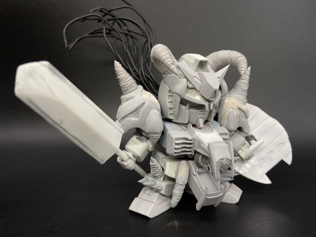 小さいドリルは市販パーツを採用。ボリューム不足のところはパテを中心に、シャープにしたいところはプラ材中心にどんどん意匠を足していきます。頭の髪(にしか見えん)は被覆の針金をさらに細い針金で束ねて後ハメ加工した頭部に捩じ込んでおります。