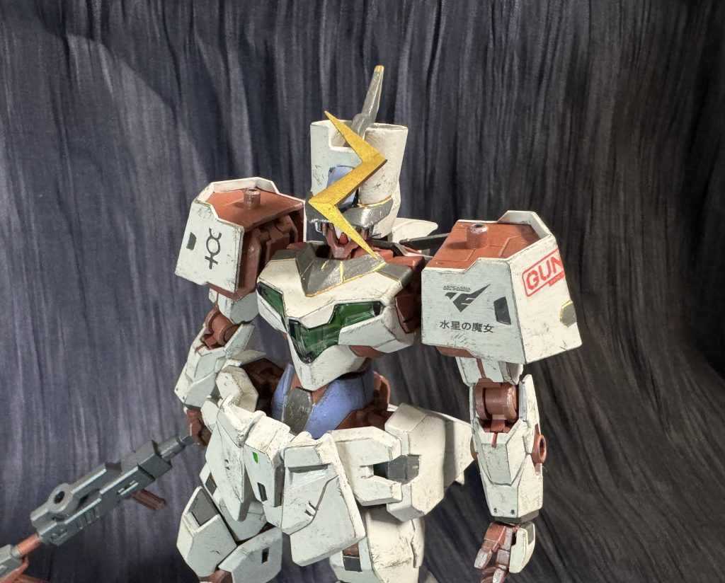 ミオリネ専用機にしようと思ったものの色どうしようと悩んで放置。ジョンブルガンダムの意匠を足したのでそっちにいくか、、、似た所でガルガンチュワにするか、でもお嬢様で主人公の妻が乗る機体だしネタ感の強い色にはしたくない。悩んだ挙句キャリバーンと対になる色にしようと考え、キャリバーンは差し色が赤だからミオリネは7話のドレスに準じて青にしようと思った訳なんです。スレッタは赤いドレスでミオリネは青いドレスでしたから。それとホルダー制服の意匠も襟元にプラス。お嬢様で妻っぽい色合いになったんでないかと。アンテナがイナズマ型してるのはミオリネの前髪モチーフとなってます。