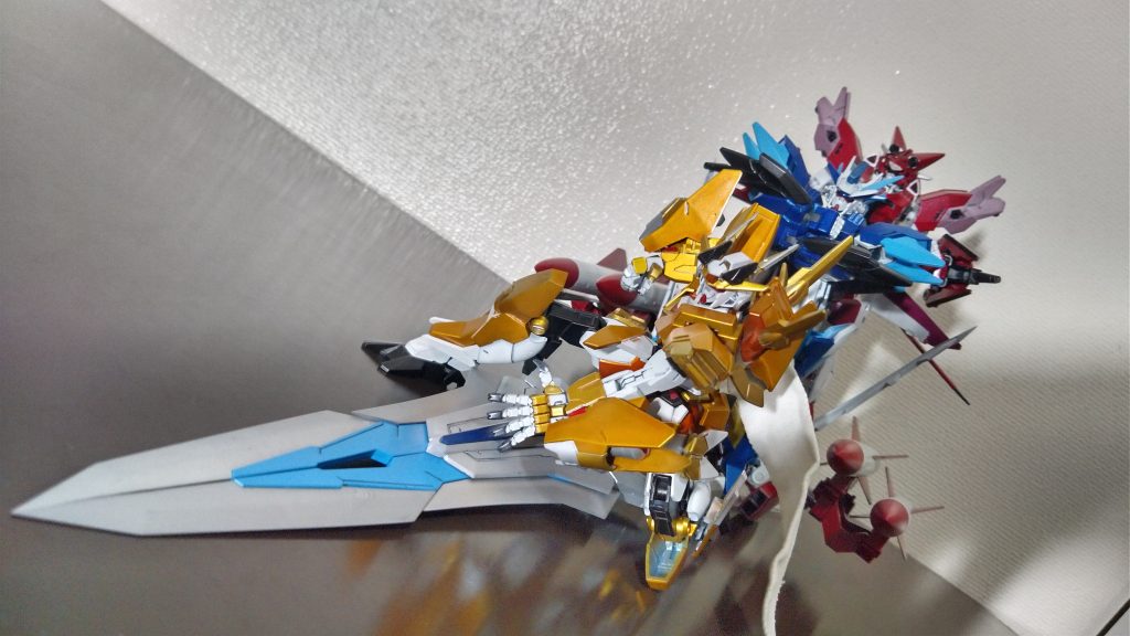 「TRINTY RESONANCS]シンフォギアAXVに登場した３人での合体技。イチイバルがスイッチをポチっと押す係で、防人がガングニールの勇姿を見る係で、ガングニールが特攻する係なのだが、ガングニールと防人が二人一緒に飛んでいく技。シンフォギアの合体技の中でも特に印象が残り、よくわからない技。ちなみに下の武器は本編だと５倍くらい大きいので、なんちゃって再現です。 