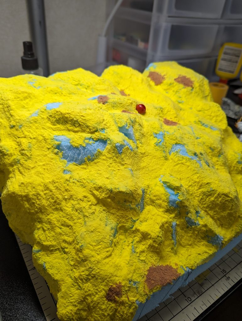 アクシズは、スタイロフォームを数枚貼り合わせて、ざっくりとカッター等で形を切り出して、表面は100均のかる粘土をつけて(黄色い部分)、アルミホイルを丸めたモノをペタペタ押し当てて質感を出しています。その後100均のコンクリートと軽く全体に塗り、アクリル絵の具で塗っています。コンクリートはどっぷり塗ってしまうと、重くて固定できないかなっと考え、かる粘土を使いましたが、黄色は余りおすすめしません。塗装後にポロポロ取れた際に黄色が出てきちゃうと目立っちゃうので、完成形の色や、違和感ない下地等の色を使用するのがいいと思います。