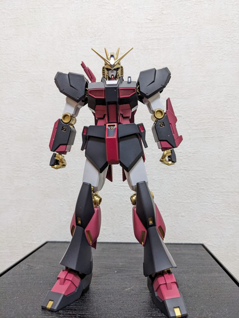 正面(武装なし)大好評❓のAve Mujicaシリーズ第2弾!!はギターボーカル担当、ドロリスこと三角初華ちゃん!!そして今回の生贄💦は、値段安い!買いやすい(いつでもどこでも売ってる)!組み易い!「やすい3拍子」のEGのνGと相成りました😆(1個め作ってあまりに気に入ったのでもう1つ買ったまま、しばらく積んでました)。「ギターボーカル」っていうバンドの「顔」なので正統派の主役機かなってのと、ドロリスの髪型とメットの形状が似てるので、νGを選びました。今回の主なポイントは、ドロリスの「仮面」の再現として、「隈取り」(初代ガンダムだと目の下の赤の部分)とフェイスパーツの左側面を黒塗りしたことと、初華ちゃんの金髪をメットで再現したこと、ドロリスの衣装の腰ベルトの茶色を近似色のシャアピンク2にしたこと、かな。※以降のAve Mujicaシリーズの説明では「口を覆うタイプ=マスク」「目の周り隠すタイプ=仮面」と表記します