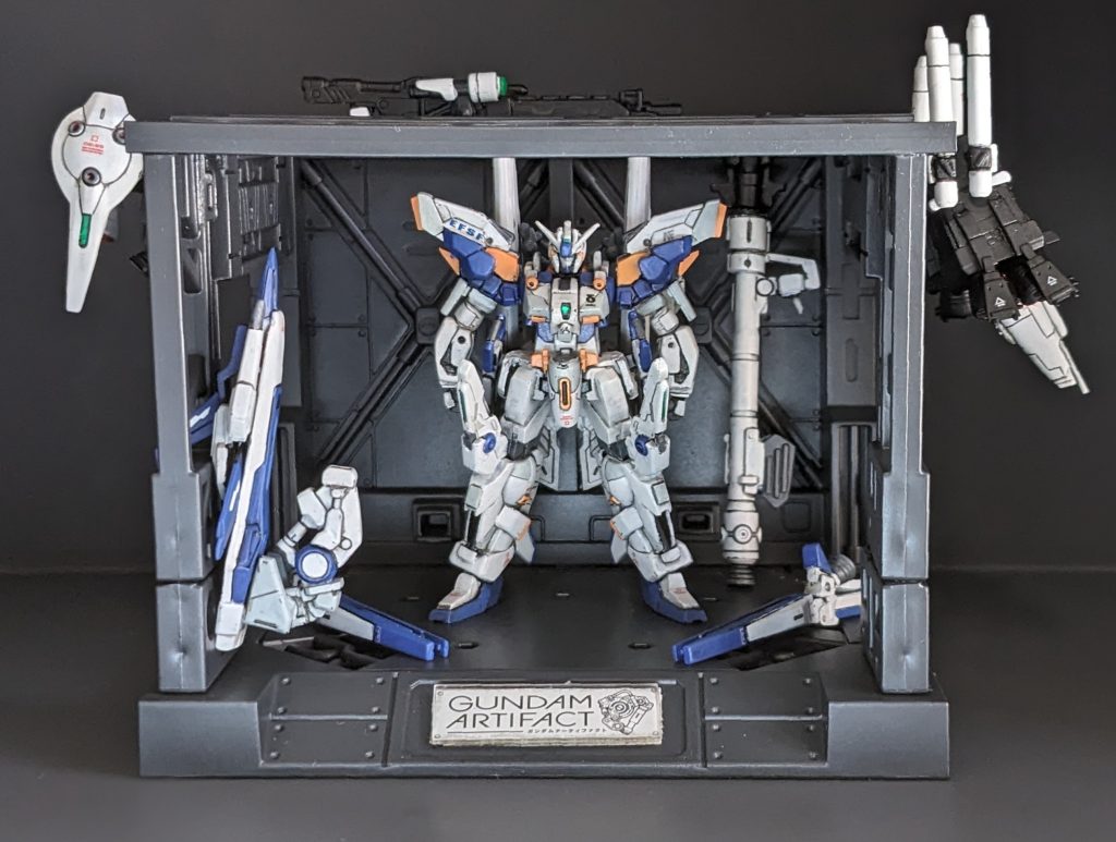 MSハンガーです。某100均アイテムを半分に切って幅を詰めてアーティファクトサイズにしています。下の真ん中にはロゴを付けてそれらしく😁ダボ穴等に武器類も引っ掛けられるので格納庫っぽく飾ることができました!