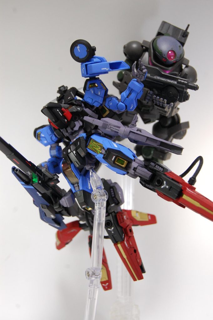 僚機と。 シェルユニットはセリアの釣り用ホロシールのオレンジ、他発光部などはダイソーの装飾テープを貼りました。腰は2mm延長、スジ掘りは一か所のみ、プラ板少々、あとはデカールで情報量を水増ししました。 本体色はMrカラーのセミグロスブラックとMSライトブルー、赤がスーパーイタリアンレッド、フレームなどがHJVパープルグレー、金色が黒下地にブルーゴールド、青色部分の差し色に水性ホビーのすみれ色。ロッドライフルはティターンズブルー2と水性ホビーのエアリアルグレーで、本体とは配色パターンを若干違うものにしました。