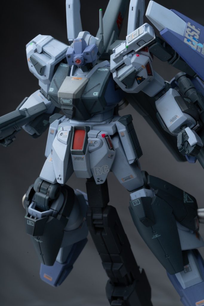 機体設定としては、元々スタークジェガンのコンセプトでもある標準機をより熟練パイロット向けに改装して対艦攻撃、追撃戦闘に特化した機体をさらに拠点制圧能力を主眼に定めており追加装甲による被弾耐久性の向上と射撃センサーの追加で主要拠点への精密射撃を可能にしています。