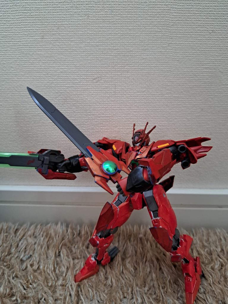 エクシアの武器から派生した「クリムゾンGNソード」と「クリムゾンGNブレイド」。実体剣のクリムゾンGNソードは戦況に合わせ刀身を収納、展開し内蔵してあるビームバルカンでの戦闘可能とする機能は武器を持ち替えずに瞬時に機能性を変える機能は非常に使い勝手が良いものであり、更にビームバルカンからビームサーベルを発生させることも可能。大型剣のクリムゾンGNブレイドはクリムゾンGNソードと対となり、刃をGN粒子で包み込むことにより、驚異的な切断力を発揮する。