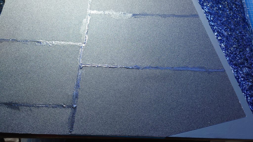 アスファルトは、180番の紙やすりを貼り合わせています。そこにジェッソと言う下地に使う画材を塗ると、良い感じに粗さが落ちてアスファルトっぽくなります。