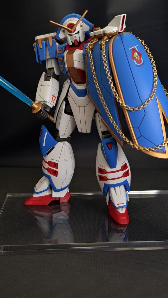 このガンダムローズで目を惹くのは、マントに付けたゴールドのチェーンですよね。私もそう思います。やって良かった加工です。実はこれ、スジボリの線が歪んだのをカバーするために付けたんです…。上手く付けるための部品探しに苦労しましたが、しっかりとミスをカバーできた上に、カッコ良くなって大成功でした!写真は、Gガンダム第4話「いざ勝負! 真紅のバラの貴公子」でやっていた謎ポーズの再現です。気になった方は15分40秒あたりをご確認ください。