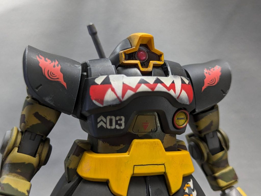 機動防御の要と言いながら、決死隊となりかねないMS部隊においては、士気高揚の効果を期待してか、特に自由な塗装が許されていたという。 本機の独特な塗装パターンは、機体の各所に描かれた虎の絵柄と合わせて、「アングリー・タイガー」とも呼ばれた。 多分、コイツの一番の見どころ「タイガーマウス」。 ドムの胴体の形状を見た時、不意に「あ、ここ口書くにはベストだわ」と思い立ったので、書いてみた次第。 実際、軍用機なんかでは現在でもたまに見られる塗装なのですが、MSではボールくらいしかやってないんですよね。 「顔以外のところを『悪役面』にする」というのも、まぁ面白いんじゃないかな、と。 ……え? 「マヌケ面」? 「暗黒大将軍」? そ、ソンナコトナイヨ……