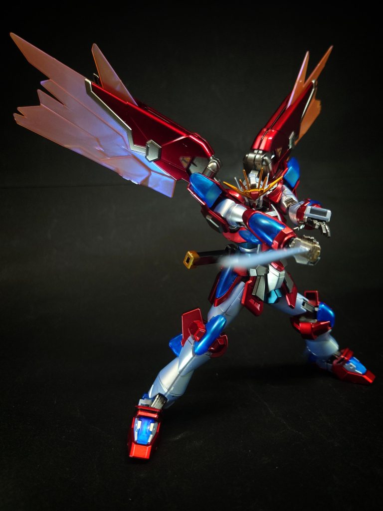 バックパックには、過去に対戦した中老ファイターが駆る漆黒のガンプラから着想を得た翼状の姿勢制御ユニット「ウイングバーニング」を装着。ユニットから放出される炎の翼で速度を高めた「攻の形」から、機体の前後を覆い防御力を高めた「威の形」へと形態を変化させる[4]