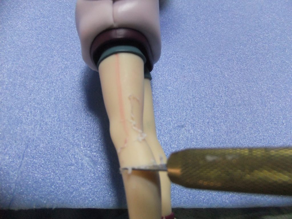 右腕、左脚のパーティングラインが目立つのでデザインナイフでカンナ掛けして段差を削り落として・・・・。