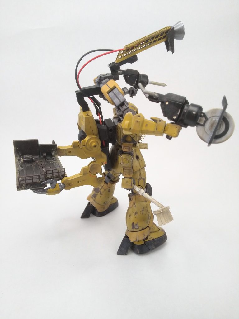 頭上にも一対のサブアームと作業補助灯を備え、大型機等の高所作業にも対応。およそMS整備に使いそうにない物騒な工具を持っているが、基地の修繕や “建築重機のバイト” で使えると、これまた整備長が趣味半分に作ったのだった。