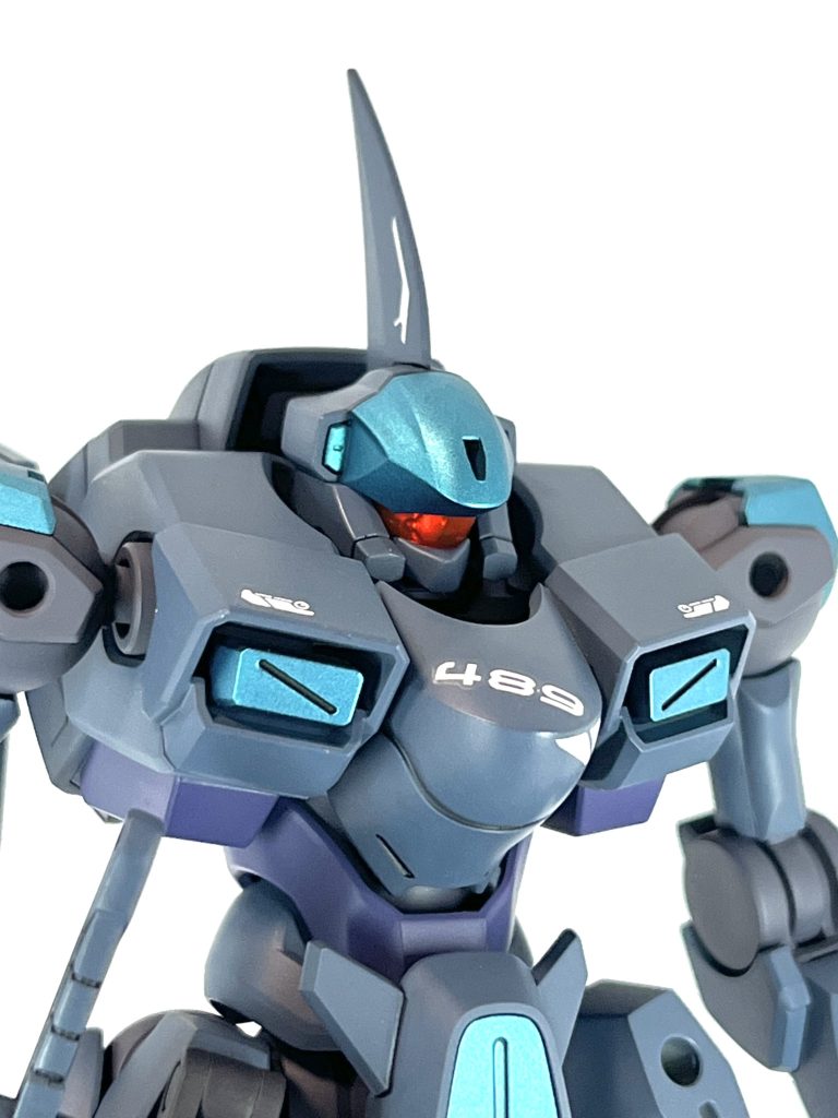 バストアップ。…僕サメ好きなんですよ。ザウォートの頭を横から見てたらサメっぽかったので、背ビレっぽいブレードアンテナをつけてサメザウォートにしました。デカールの「489」はシャークの意名前「ザウォート・ハイ」も「high」と「hai(ドイツ語でサメ)」のダブルミーニングです。バイザーアイ奥のメカモールドはシルバー塗装して、クリアーパーツ越しでもカッコよく見えるようにしました。