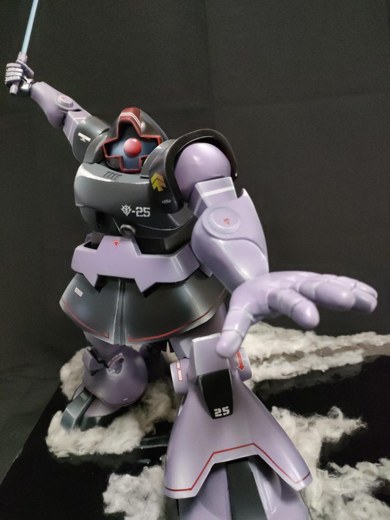 腕も手首と肘の前後で大きさを変えて遠近感を追求。左手指は1.5ミリ針金にポリパテを棒状にして刺してから粘土ベラで整形してスクラッチ。顔と頭部をポスターの比率に改造するのに一番苦労しました。モノアイは林哲平先生のスゴ技の1つ、透明プラ板にレジン表面張力加工で作成。今回うまく出来たと思うのが白いハイライトをエアブラシでグラデーションかけた上に筆でピンポイントまたはライン状にハイライトを重ねる塗り方。モノアイと腰スカートと肩辺りに注目