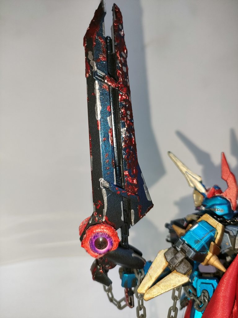 「邪剣トライエッジ」禍々しい邪気を放ち、数多の戦場で血を浴び続け、魂を喰らった悍ましい邪剣。この朽ち果てた鎧装もしくは機体に寄生し、その邪悪なる意思で動かす主人格のような存在。