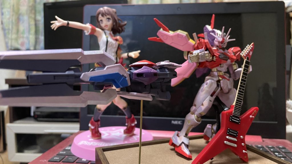 Poppin’Partyのメインボーカル&ギター戸山香澄のフィギュアと共にランダムスターを弾いて武器を召喚した風に