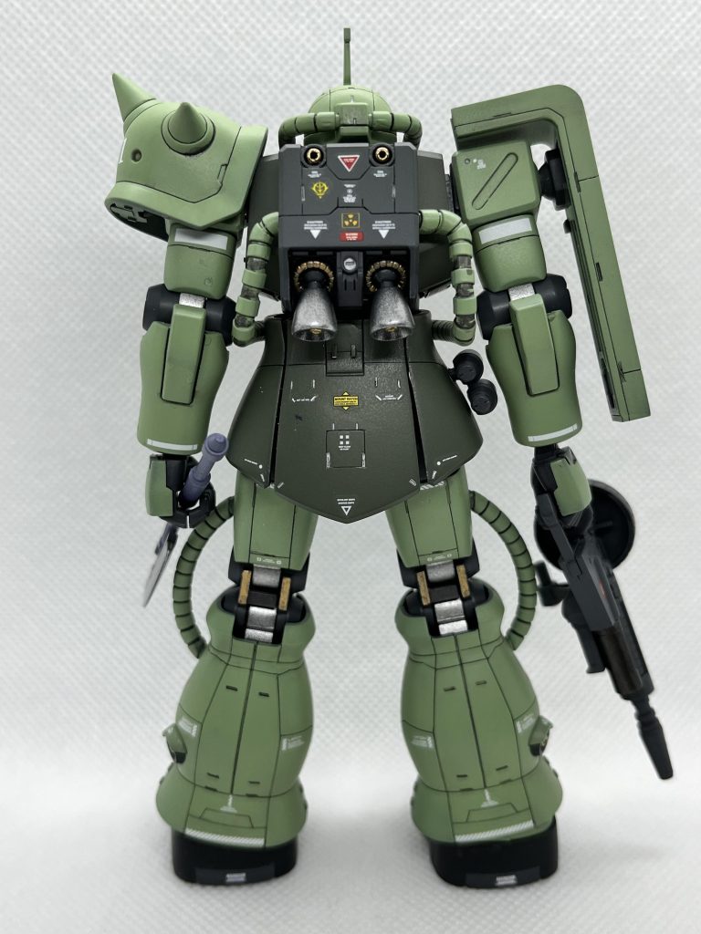 背後より。軍部からの要求は以下の通り。1 従来機ではモジュールの交換で空間戦と地上戦に対応してきたが、これを必要とせず、どちらの環境にも対応できること。またコストカットを実現すること。2 弾薬は、共通としつつ、武装についても改良すること。3   F型で機動面な稼働時間が優れていること。以上である。なかなか難しい要求ではあるが、ジオニック社としても、旗艦商品であるザクの改良に熱が入らない訳がなかった。要求に応えるべく、開発が進められた。