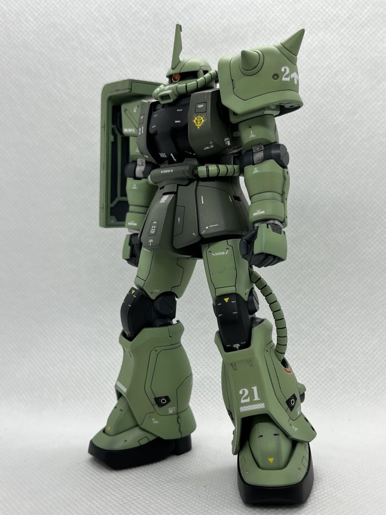 左側前方より。主戦場は地球へと移った。空間戦闘用と、地上戦闘用をを分けて開発する事はナンセンスである。そこで軍部は、F型のマイナーチェンジ及び武装の最適化をジオニック社に命じた。実はこの問題をジオニック社としても認識しており、かなり早い時期から研究がされていたため、設計から試作までごく短時間で完成させることができた。06F改として試作されたのが本機である。四肢は生産性の向上を目指し、原型機よりも直線的なデザインとなっている。なお頭部ブレードアンテナは隊長機を示す物ではなく、テストチームとして通信能力を向上させる必要があったからである。