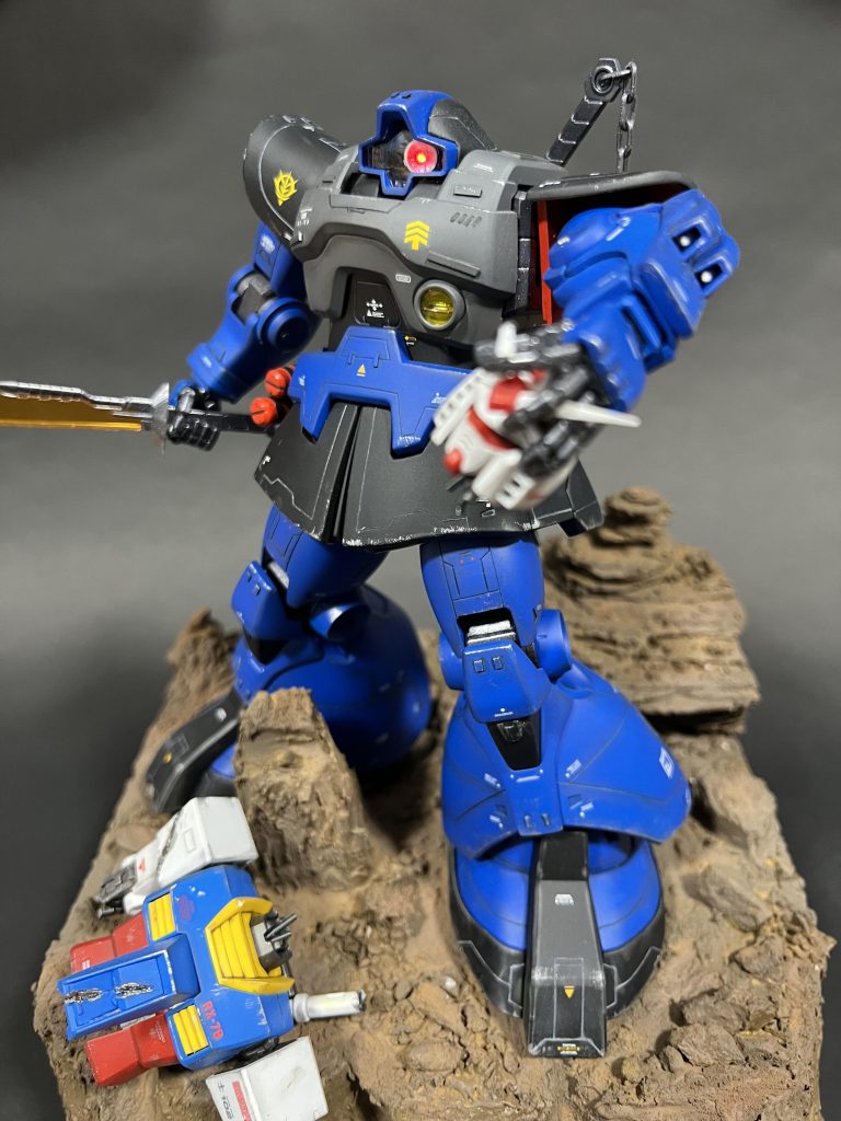 機体ベースはMGドムver2.0を使用。機体各所にスジボリやダクト等を追加して、情報量を増やしてディテールアップ。モノアイにはLEDを仕込み光るように。またジオラマ台座には岩場をイメージしてガンダムを痛め付け配置してみました。