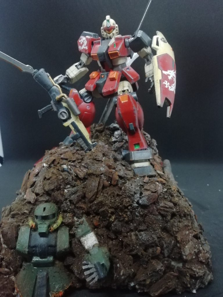 剣や銃の配置方法を工夫することで、コンパクトな作品に奥行きを持たせている。前作では、ジオラマとして制作していましたが、今作では構成を練り直して、ヴィネットとして、制作し直す。 機体設定としては、ユーラシア大陸方面軍、香港支部所属の部隊(エゥーゴにもティターンズにも属さない連邦軍)と 「親ティターンズ支持派閥」との密約により譲渡された機体。 ベース機はジム・クェル。部隊のパーソナルカラーリングに変更、 外装の形状も一部変更されている。