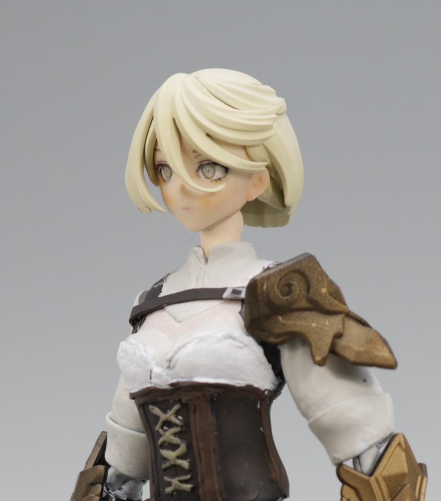 金髪のミオリネさんです。世界観をファンタジー的な冒険者にしたかったので、それっぽい装いにしました。FF14とかFFTとかを参考にしています。胸のあたりの肩パットを付けるベルトが気に入ってます。