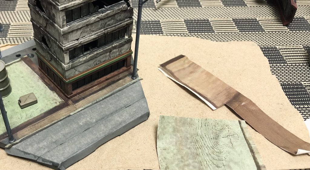 100均のタイルシートで空き地や歩道、路側帯に花壇などを表現、マスキングで道路。最後にエナメルウォッシングしてます。アーマーモデリング11月号のロードベース特集を3回は立ち読みしました。