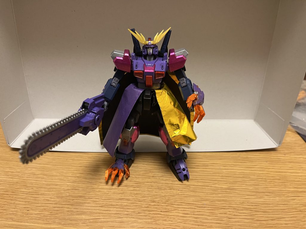 機体名:ガンダムゴッズバッファ全高:18.8m重量:27.4t「全てのガンダムをぶっ潰す力」という願いに、オリジナルのDG細胞とアルティメット細胞が同時に呼応して具現化し、パワーアップを遂げたガンダムバッファの強化形態。紫の重厚な装甲に加えて、新たに頭部のアンテナが大型化・金色になり、紫のマントと金色のローブが追加されている。性能本形態に至る為には、アルティメット細胞を新たに取り込み、オリジナルのDG細胞と同調する事で成り立つ。一応、パイロットの意思で元の姿に戻る事も可能。アンリミテッドエンジン従来よりも出力が大幅に強化され、宇宙空間でも問題なく活動できるほどの高い機動力と推進力を獲得し、重力下の単独飛行が可能となる。対ガンダム特効能力下記以外は従来の性能と変わらないが、最大の特徴は、対ガンダム戦に究極的に特化した以下の装備・特殊能力にあり、ガンダムタイプのMSに対して比類なき絶大な戦闘能力を発揮する。これらの以下の装備自体も、ガンダムタイプの有無に関わらず、耐久性と強度は極めて高く、核ミサイル数十発を食らっても無傷でいられるほどであり、破壊して弱体化させる事は困難を極める。※ガンダムタイプの分類に対する有効範囲はかなり広く、単なるワンオフ機としてガンダムの名前を持つMSだけに限らず、戦略兵器かつ量産型でもあるデストロインガンダム、「ガンダムを超えた存在」としてガンダムの名前を外されたダブルオーライザーやクアンタ、ガンダムタイプと同等の存在として扱われるターンXなど、例えガンダムの名を有していないMSでも、ガンダムタイプの意匠や兄弟機などであろうが、問題なく適用される。