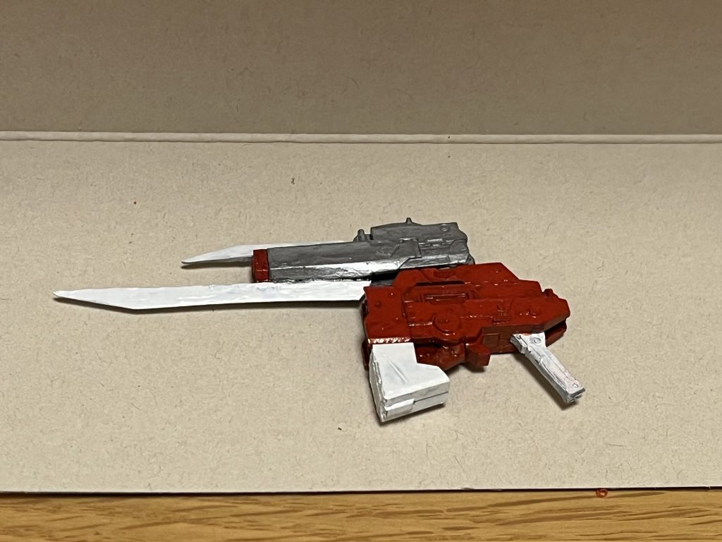 レールガンモード射撃メインの形態で、貫通力特化のレールガンと、広範囲攻撃特化のビームライフルの2種類に使い分けて使用できる。本機から供給されるエネルギーを高密度に超圧縮し、生成された特殊エネルギーマテリアルをビーム・実弾に変換し、上下の刀身を電極として、中央部銃口から高速射出する仕組みになっており、いずれもその威力は極めて高い上に、連射性能も通常のビームライフルとほぼ同じ間隔で使用可能。また、銃口付近はブレードモードの刀身・剣先である為、銃剣のように近接武器としても使用できる。レールガン放たれたダインスレイヴの弾丸ごとPS製のMS数十体を一撃で貫通するほどの破壊力を有しており、その連射性能の高さも相まって、戦略兵器のダインスレイヴですら遥かに上回る貫通力を誇る。ビームライフルナノラミネートアーマー製やFT装甲を持つMSを纏めて撃破し、出力を上げれば、戦艦を複数隻ですら一撃で撃破可能とするなど、ビームライフルの枠に全く収まらない規格外の破壊力を誇る。