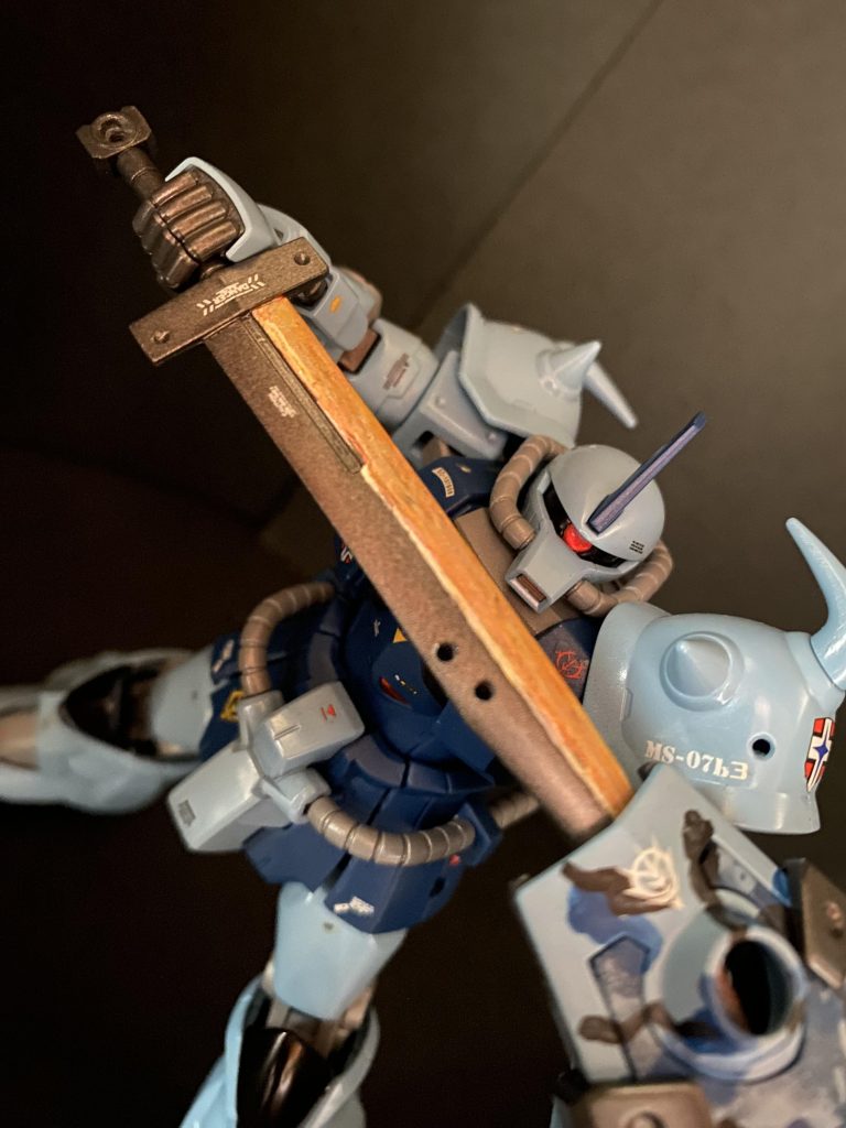 シールドは白兵戦用装備であるヒートサーベルの収納装置も兼ねており、またこれに増設する事のできる75mm大型ガトリングガンは本機最大の攻撃用兵装とされている。一般にはシールドガトリングと称されるこの複合兵装は、白兵戦時には銃砲部分をパージすることによりデッドウェイト化することを避けることが出来た。