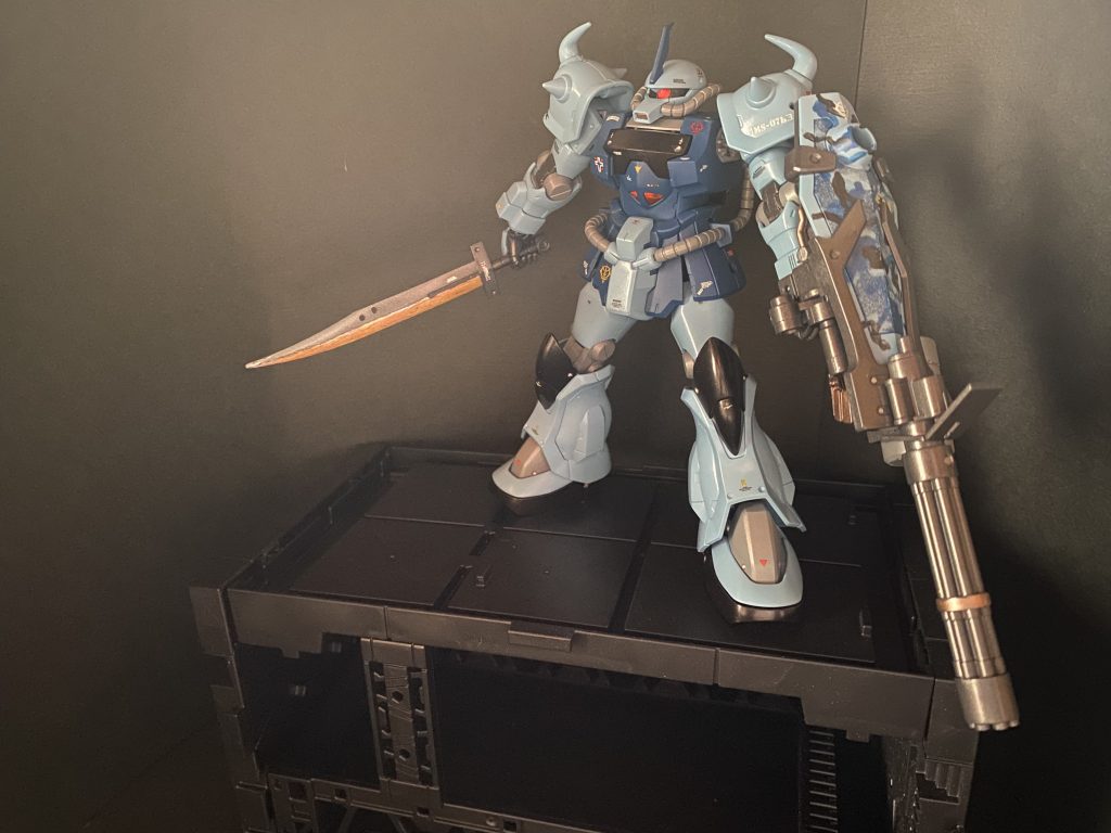 MS-07グフは公国軍の宇宙での主力機となったザクIIを地上仕様として改修したJ型を経て、本格的な地上戦用機として開発された。開発はザク系統を生み出したジオニック社によって行われ、約4割のパーツはJ型からの流用が可能であり、生産ラインの切り替えも比較的容易であったとされる。拡大した地球戦線においては現地改修を含む派生型もいくつか投入されたが、中でも後期生産分の純粋なる性能向上モデルと位置付けられるのがB3型であった。一部ではグフ・カスタムの愛称で呼ばれたこの機体は、原型機の実戦運用にて現場から上がってきた問題点を洗い直し、ジオン本国の開発局にてパーツ単位から再設計。弱点であった中距離戦や汎用性を強化した、ワンランク上の改良型である。