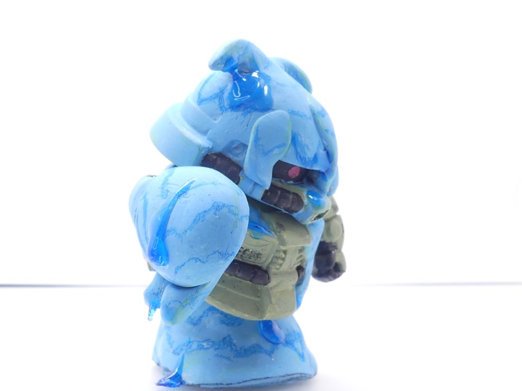 モンスーツ・スライム:モンスーツの中で最下層最弱とされる個体。SDガンダムのNPD大の姿を取る。動きは遅く攻撃も体当たりや粘液弾程度のものであるが、一般的なガンプラの攻撃は通じないため複数が現れれば大型ガンプラでさえ簡単に駆逐する。粘液弾だけでも、ダイバーに感覚上のダメージを与えるのには十分なものである。何度も食らえば現実世界へのダメージは免れることはできない。スライムの方はエポパテを盛り粘液の垂れ方に気を遣いつつUVレジンでそれっぽく・・・模様は油性色鉛筆で手書き。エポパテの芯はポケプラのジャンクパーツから。底面もザクの頭などからできています。よく見られるスライムと違い、頭に何か伸びていますがその理由は製作ストーリー(製作中)で・・・