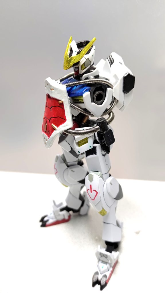 風雲再起に乗せたところ、背中にマウントされた太刀が風雲再起に刺さるという問題が発覚しまして・・・太刀のマウントを背中から腰回りに移動しました。余剰品の適当なポリキャップにマウント用パーツを装着し、反対側にマイナスモールドを貼り付けてスプリングで腰をぐるっと囲んでいます。腰が大きくくびれたバルバトスならではの装着方法ですね。ただ、このパーツは腰に吊るしただけで体に固定してません。ポージングによって腰の左側または後ろ側に太刀を移せるようにするためです。以下、アクションポーズです。