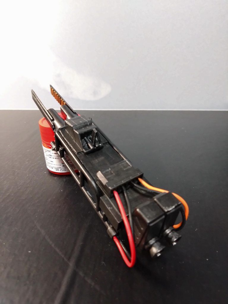 プラ板箱組みの左右のパイピング?らしいのは100均の足場の模型を半分に切断したものです。それに繋がるのは何かの電装部品のカプラーを接着してプライマー塗ってから塗装してます。カプラーからの配線を足場パーツに接着してます。ガンのグリップ部分は何かのバーニア基部にプラ板接着してグリップにしてます。ガンの先端はコレまた100均のタバコフィルターにプラ板接着してます。後からそれっぽく見えるようにプラ板の内部に細く切ったプラ板を9枚接着してゴールドに塗装しました。それっぽいかなぁ?😅