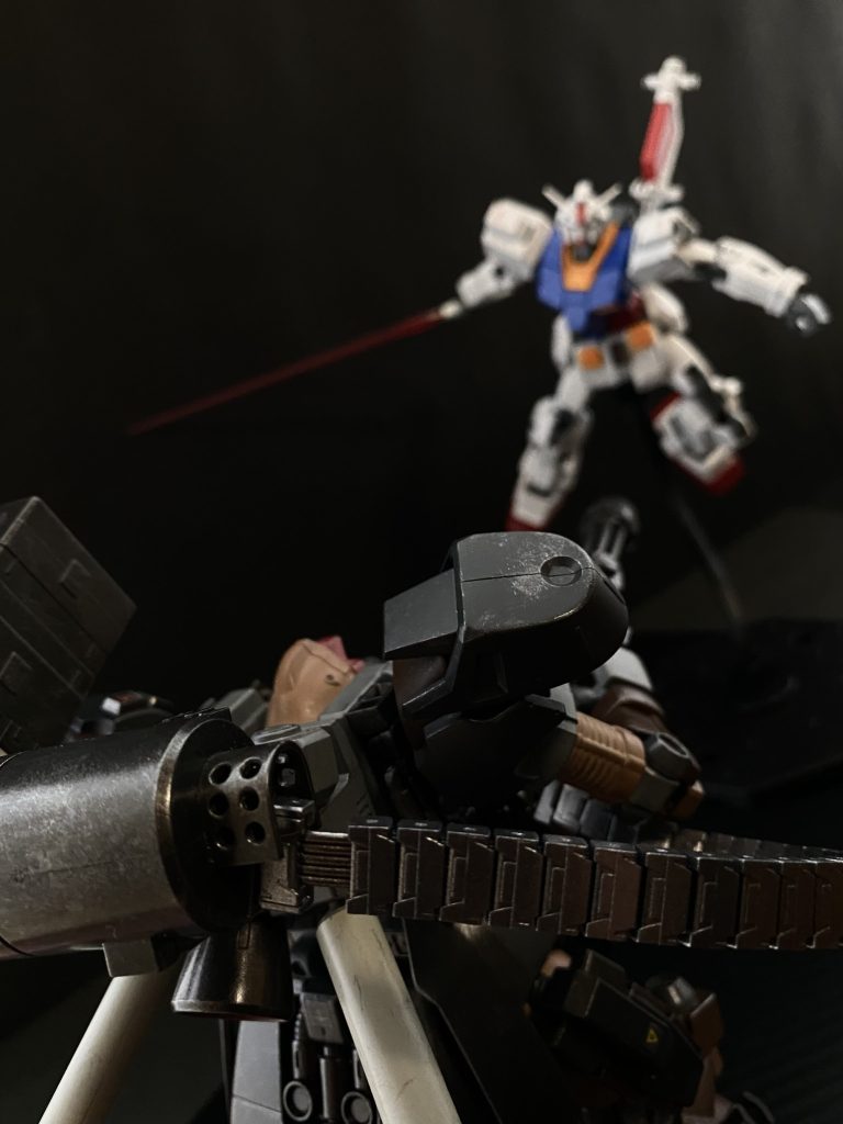 「とにかくひけっ!さがれっ、コイツらはヤバい」 引けない、引かせてくれないのはわかる。がそう叫ぶしかないのだ。その時、クルト機の放ったシュツルムファウストが何かの残骸に当たり、爆発が起こる。「よし、爆発を盾に撤退す…」 その瞬間、爆発の中から一条の光が奔ると、撤退の為、背を向けたクルト機のバックパックを貫く。なんだ…?ヤツはこっちが「見えて」いるのか。クルトは…?大丈夫か…。 …自分は大丈夫ですよ。クルトからの返事に胸を撫で下ろすのもつかの間、アリシャが叫ぶ。「大尉っ!もう一機が」 アリシャの声が聞こえるのと同時に、目の前の残骸の陰から白い小柄な機体が踊り出る。…っ!どこからきたっ、レーダーには反応が無かった。その機体。「ガンダム」は、一振りのビームサーベルを発振させると、周囲の残骸や、岩塊を蹴りその反動でこちらに切り掛かって来る。そうか、そうしてスラスターを使わずに移動して来たのか、そして小柄に見えたのは、ライフルもシールドの類いも持っていないからか。 そのガンダムは、踊るように、残骸と岩塊、そして、ドムの間を舞う。